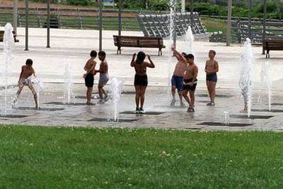 Unos niños con sobrepeso juegan en las fuentes del parque Juan Carlos I de Madrid.