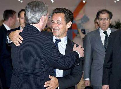 Nicolas Sarkozy (de frente) abraza a Jean Claude Juncker a su llegada a la reunión del Eurogrupo.