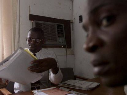 El doctor Wole Daini, enfermo de SIDA, lee el informe de un paciente afectado por el VIH, en Lagos, Nigeria.