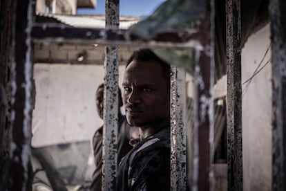 Un hombre mira desde un almacén quemado y saqueado, presuntamente, por rebeldes tigriñas en Shewa Robit, norte de Etiopía, el cinco de diciembre de 2021.