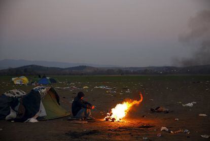 Un inmigrante marroquí se calienta en una hoguera cerca de la frontera con Macedonia en la aldea griega de Idomeni.
