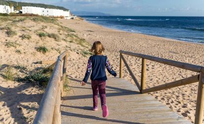 A la playa de Caños de Meca (Cádiz), paraíso jipi en otros tiempos, se accede por una pasarela de madera. El faro del cabo de Trafalgar escolta la bahía.