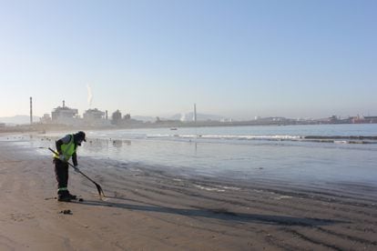 Los propios pescadores se encargan de limpiar las trazas de carbón que deja la actividad de las industrias en la playa.