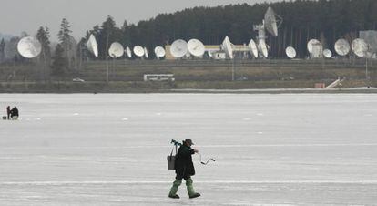 Un pescador camina ante el centro de comunicaci&oacute;n espacial de Zheleznogorsk, en 2014.