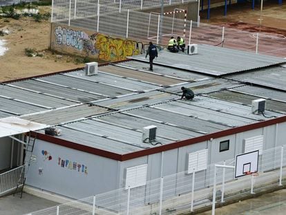 Operarios trabajan en los tejados de los barracones del colegio 103 de Valencia.