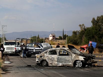 Policías municipales junto a un coche quemado en Celaya, México.