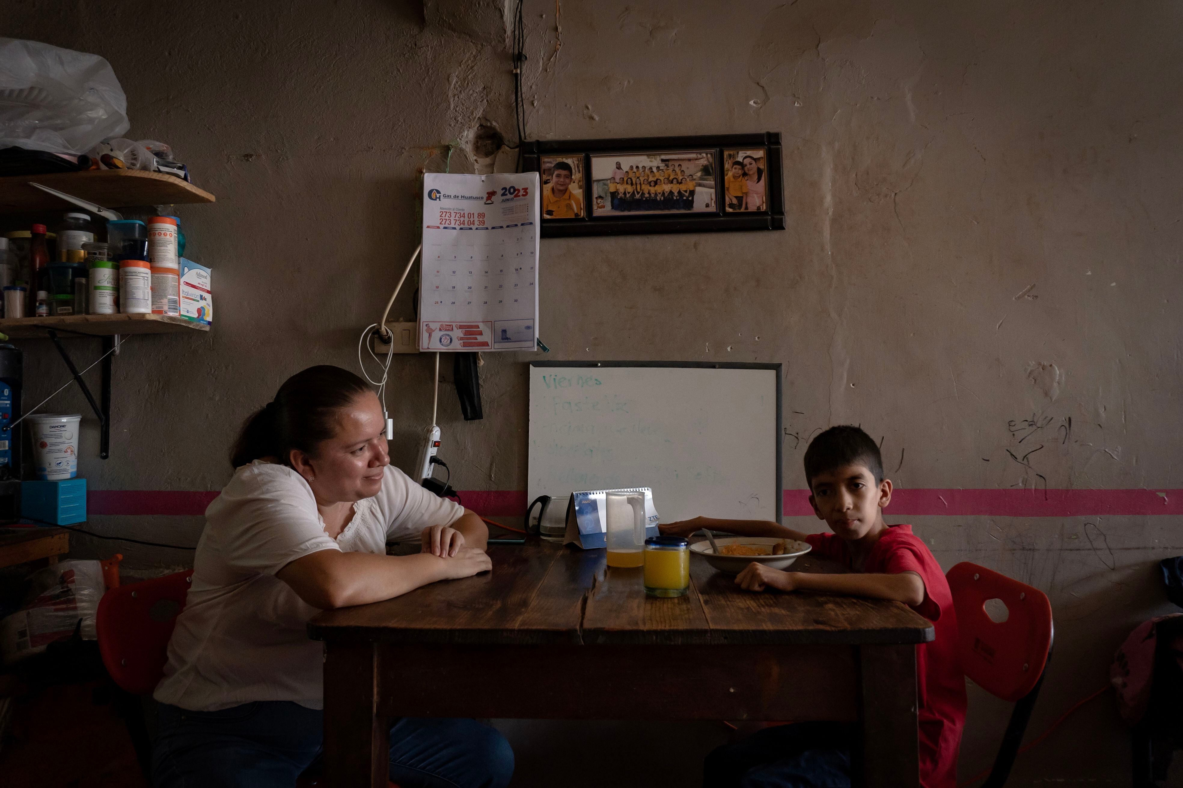 Edgar García, paciente de ataxia de 10 años, come en compañía de su mamá Librada Morales.