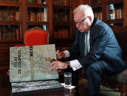 El ministro de Exteriores, Jos&eacute; Manuel Garc&iacute;a-Margallo, observa un atlas durante su visita, este viernes, a la Canciller&iacute;a de Bogot&aacute;.