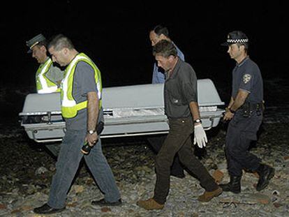 Agentes de la Guardia Civil trasladan el cuerpo del subsahariano hallado muerto en Ceuta.