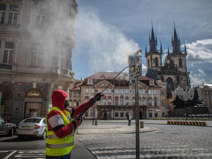 Un trabajador limpia una señal de tráfico en Praga (República Checa) el 1 de mayo