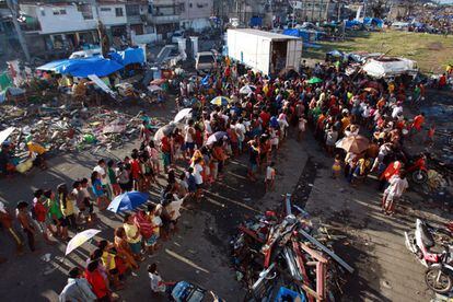 Cientos de personas esperan su turno para recoger la ayuda alimentaria que se está repartiendo en la ciudad de Tacloban, 15 de noviembre de 2013.