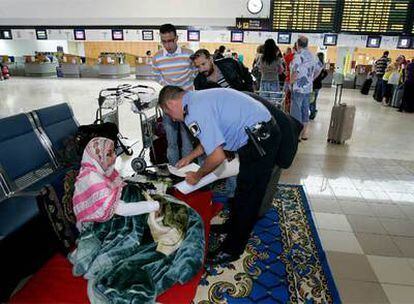 Un agente conversa con la activista saharaui en la terminal del aeropuerto de Lanzarote.