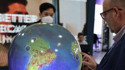 Un visitante contempla un globo terráqueo en la cumbre del clima COP27, celebrada en Egipto.