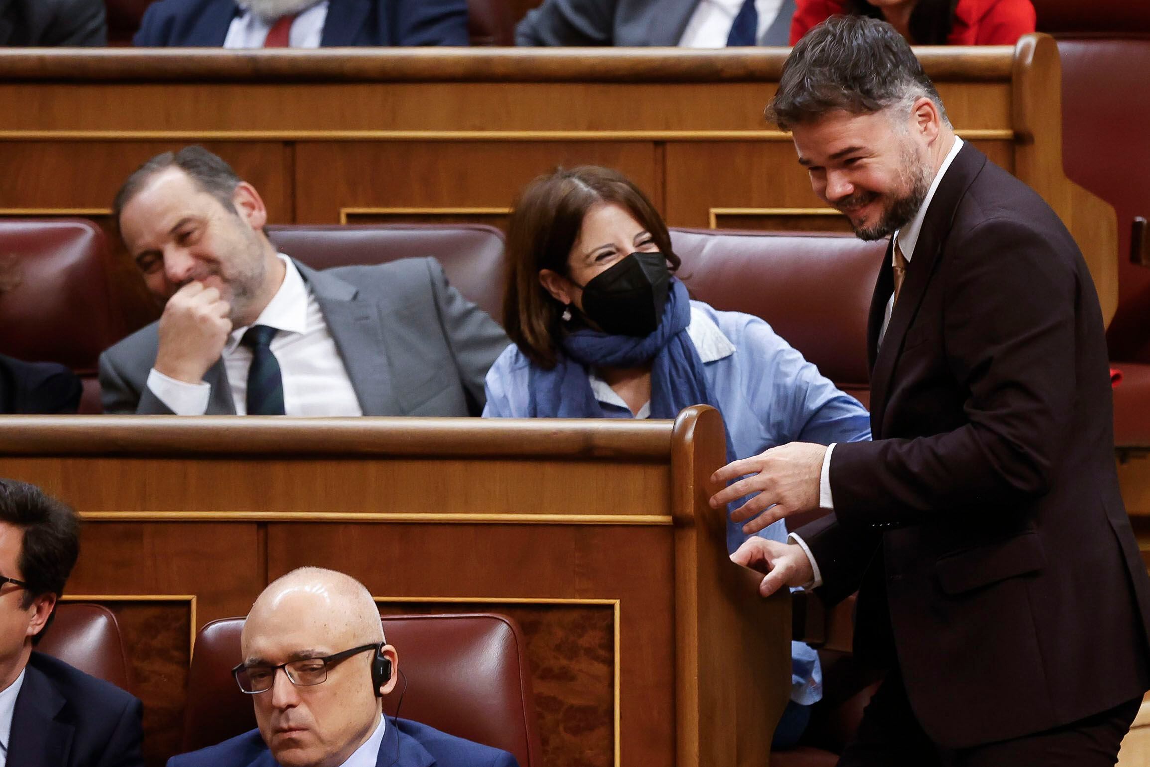 El portavoz de ERC en el Congreso, Gabriel Rufián, bromea con los diputados socialistas Adriana Lastra y José Luis Ábalos durante la segunda jornada de la investidura de Pedro Sánchez. 