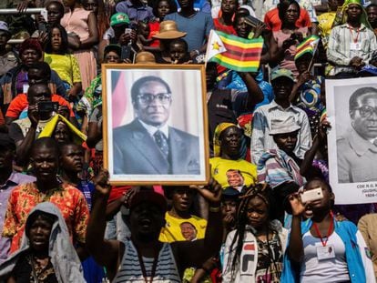 Decenas de zimbabuenses con fotos de Mugabe, este sábado durante una ceremonia en Harare. En vídeo, perfil de Mugabe.