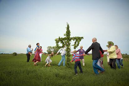 Un grupo de personas bailando alrededor del mayo durante las fiestas del Midsommar en Suecia.