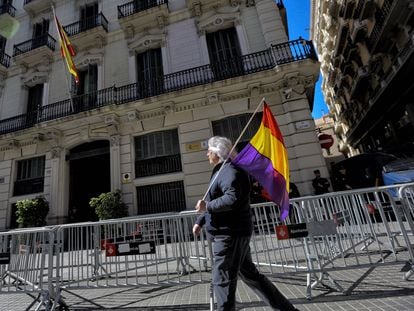 Una persona con una bandera republicana pasa esta mañana por delante de la Jefatura Superior de Policía de Cataluña en Via Laietana de Barcelona.