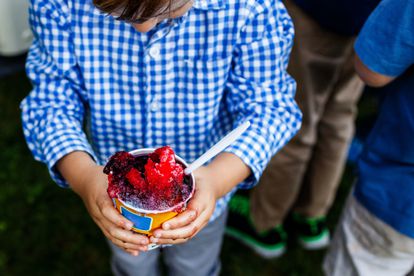 Un niño sujeta un sorbete de frutos rojos.