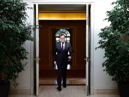 Mariano Rajoy cruza una puerta en La Moncloa.