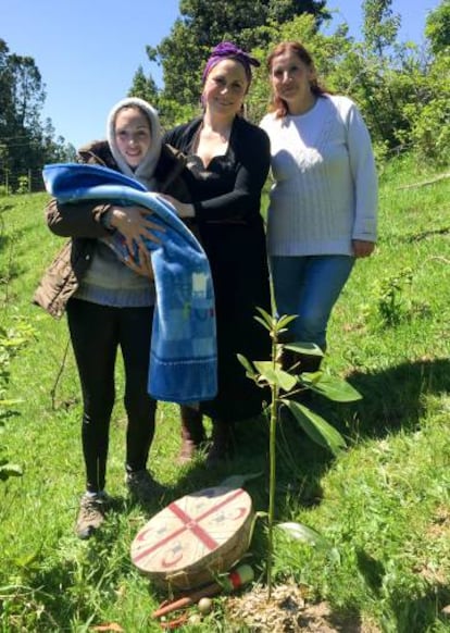 Yoana Aron junto con dos miembros de la comunidad huilliche tras la celebración en la que se plantó la placenta junto con un pequeño árbol.