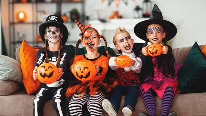 Varios niños disfrazados en Halloween enseñan sus calabazas