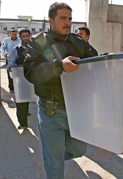 Policías iraquíes transportan en Basora urnas para los comicios.