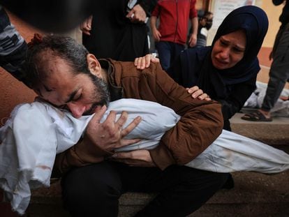 Jamil al-Agha y su esposa lloran mientras abrazan el cadáver de uno de sus dos hijos muertos en un bombardeo israelí en Jan Yunis, este domingo.