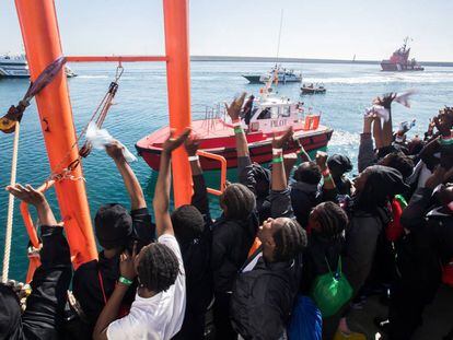 Los migrantes del 'Aquarius' saludan a los barcos que les reciben al llegar a Valencia, el domingo.