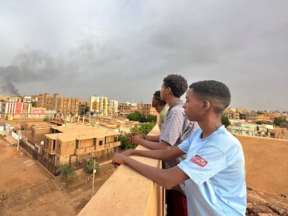 Unos adolescentes observan el humo de los combates entre el ejército y paramilitares en la ciudad sudanesa de Omdurman, el 4 de julio.