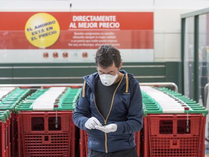 Un hombre mira su móvil en un supermercado de Madrid.