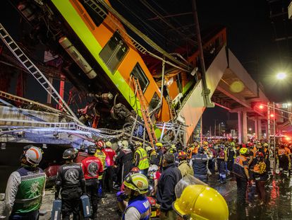 Trabajadores humanitarios y rescatistas frente a los escombros después de que una sección de un puente en la línea 12 del metro de Ciudad de México colapsara, el 3 de mayo de 2021.