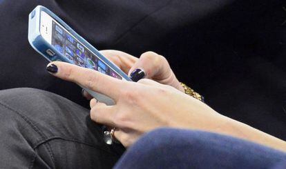 Una mujer consulta su teléfono móvil.