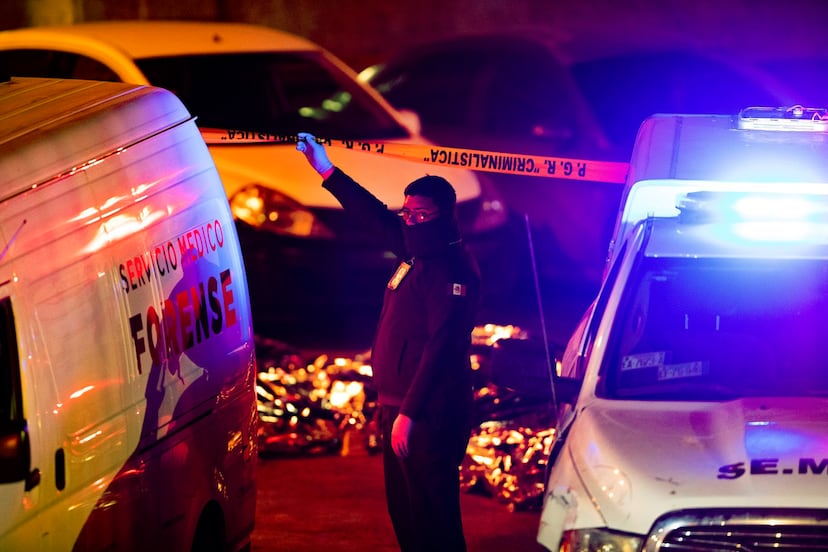 Un perito levanta la cinta del cerco policial para ingresar a la zona del siniestro a atender a las víctimas. 