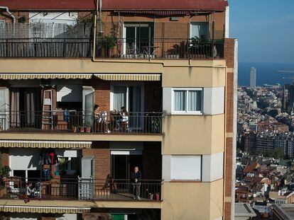 Los vecinos de un edificio de Barcelona se asoman a sus terrazas durante el confinamiento.