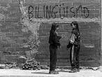 Dos adolescentes conversan junto a una de las pintadas a favor del bilingüismo que aparecieron  en Barcelona en 1997.