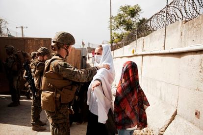 Una soldada registra a una civil el 18 de agosto de 2021 en el aeropuerto de Kabul, Afganistán.