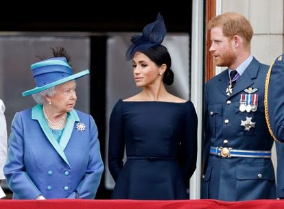 Isabel II, junto a su nieto, el príncipe Enrique y su esposa, Meghan Markle, en el Palacio de Buckingham, en julio de 2018. 
