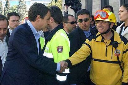 Zapatero felicita a un miembro de los equipos de emergencia que han participado en la extinción del incendio.