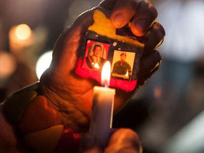 Una persona sostiene dos fotografías del Presidente de Venezuela Hugo Chávez durante un ritual indígena por su salud