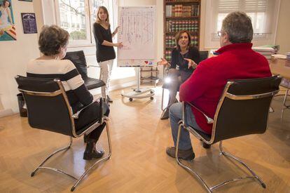 Las mediadoras Mar&iacute;a Quero (izquierda, de pie) y Yolanda Ram&iacute;rez durante una de las sesiones de mediaci&oacute;n de los L&oacute;pez (de espaldas).