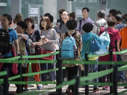 Pasajeros aguardando en la cola de los controles del aeropuerto del Prat, este martes.