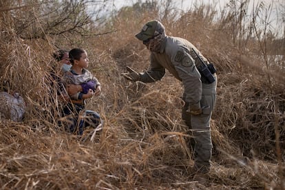 Un policía texano conversa con una solicitante de asilo hondureña y su hijo de 4 años después de que estos cruzaran el Río Bravo el 9 de marzo en Peñitas, en el Valle del Río Grande.