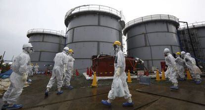 Empleados de Tokyo Electric Power pasan por delante de tanques con agua radioactiva en la central nuclear de Fukushima, 7 de noviembre de 2013.