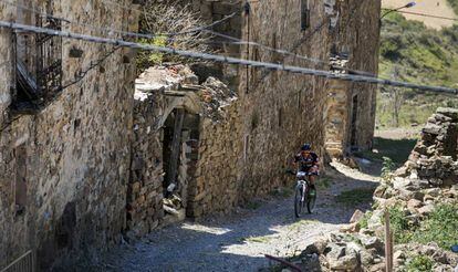 Un ciclista pasea entre casas abandonadas de Sarnago (Soria).