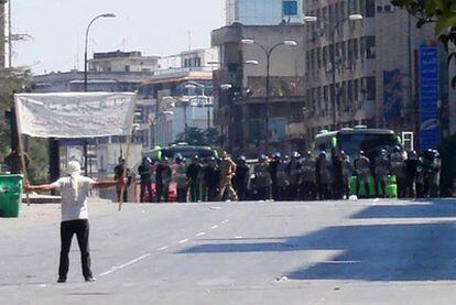 Un manifestante se enfrenta a la policía antidisturbios en Jalidia, cerca de Homs, ayer.