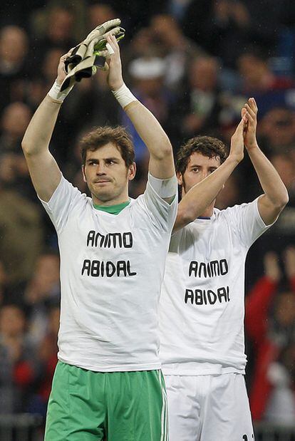 Iker Casillas y Esteban Granero, con una camiseta de animo al defensa del Barcelona Eric Abidal después del partido de Liga de Campeones contra el Olympique.
