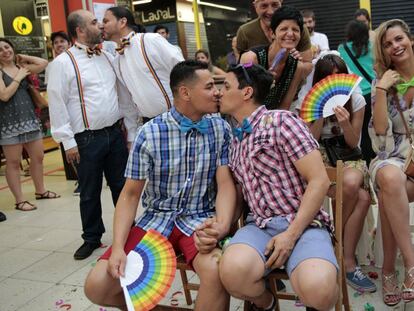 Un grupo de parejas se besan durante una boda multitudinaria en el Mercado de San Fernando en Madrid.