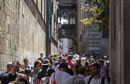Riada de turistas en la calle del Bisbe, junto a la catedral en el barrio Gòtic de Barcelona.