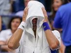 Novak Djokovic, of Serbia, cries as he sits on his bench during a changeover in the third set of the men's singles final against Daniil Medvedev, of Russia, of the US Open tennis championships, Sunday, Sept. 12, 2021, in New York. (AP Photo/John Minchillo)