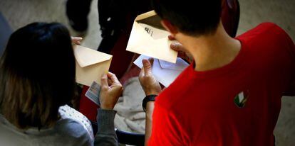 Una pareja con las papeletas para votar en un colegio electoral de Madrid el pasado mayo.